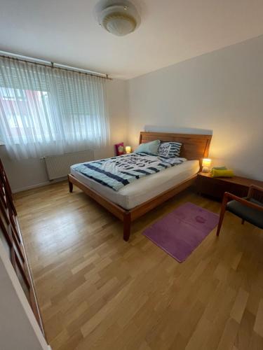 a bedroom with a bed and a wooden floor at Lovely Modern Apartment - Lake Jarun in Zagreb