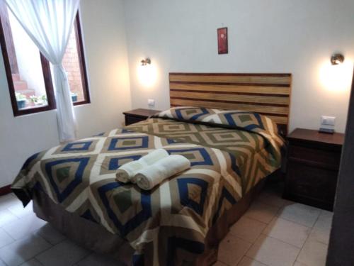 a bedroom with a bed with two towels on it at Hotel Casolia in Quetzaltenango
