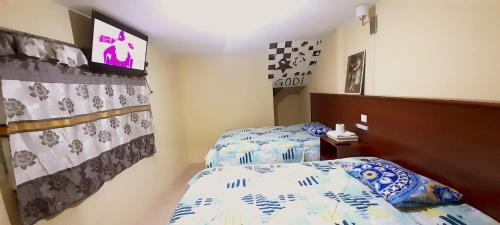 a bedroom with two twin beds and a tv at Hotel Ideal, Your House in Quetzaltenango in Quetzaltenango