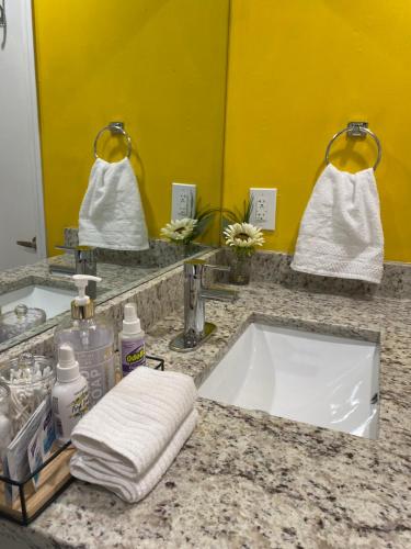 a bathroom counter with a sink and a mirror at Wine Down Suite King Bd, 400mbps, Kitchen,Free Parking Pool in Atlanta