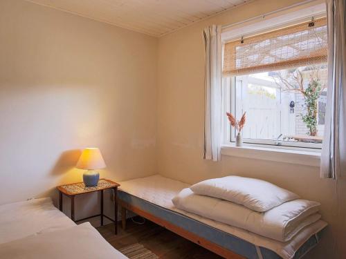 Cette chambre comprend deux lits et une fenêtre avec un banc. dans l'établissement Holiday home Jægerspris XLI, à Jægerspris