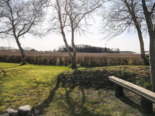 a bench in a park with trees and a field at 4 person holiday home in Jægerspris-By Traum in Jægerspris
