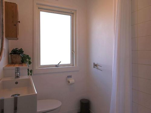 La salle de bains est pourvue d'une fenêtre, de toilettes et d'un lavabo. dans l'établissement Holiday home Jægerspris XLI, à Jægerspris