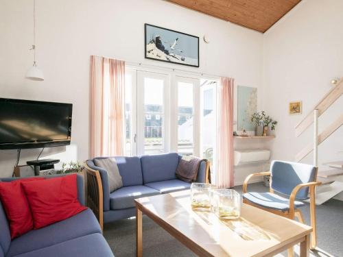 Vestervigにある5 person holiday home in Vestervigのリビングルーム(青いソファ、テーブル付)