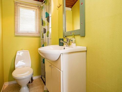 a yellow bathroom with a sink and a toilet at 6 person holiday home in Farsø-By Traum in Farsø