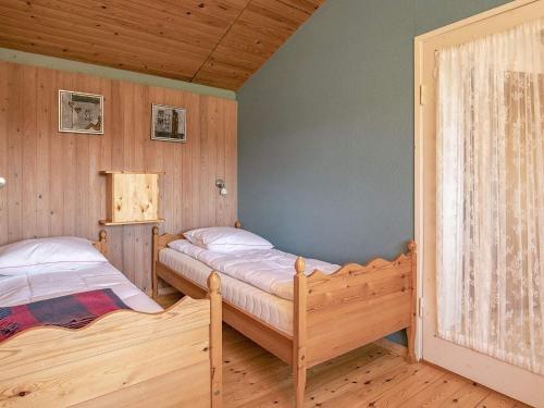 two beds in a room with wooden walls at 6 person holiday home in Farsø-By Traum in Farsø