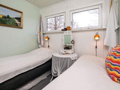 een kleine slaapkamer met 2 bedden en een spiegel bij Holiday Home Fyrrevej in Thyholm