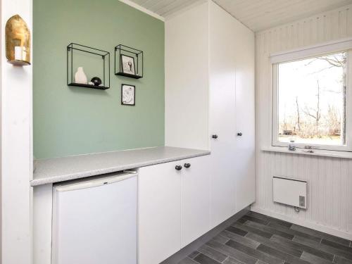 a bathroom with white cabinets and a window at Holiday Home Fyrrevej in Thyholm