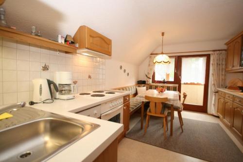 eine Küche mit einem Waschbecken und einem Tisch darin in der Unterkunft Haus Meissnitzer in Haus im Ennstal