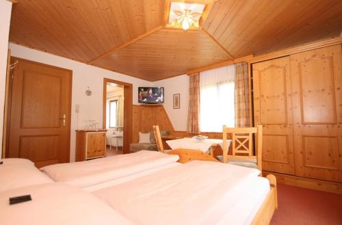 a bedroom with three beds and a tv in it at Haus Meissnitzer in Haus im Ennstal