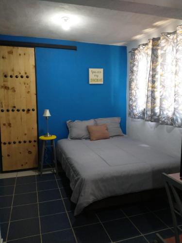 a bedroom with a bed with a blue wall at Casa LUNA in La Paz