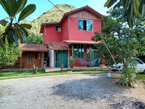 ノバ・フリブルゴにあるLoft da Serra e Kitnet na Serraの山を背景にした赤い家
