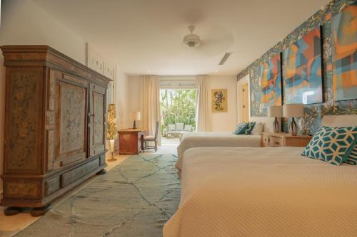 1 Schlafzimmer mit 2 Betten und einem großen Holzschrank in der Unterkunft Luxurious fully-staffed villa with amazing view in exclusive golf & beach resort in Punta Cana