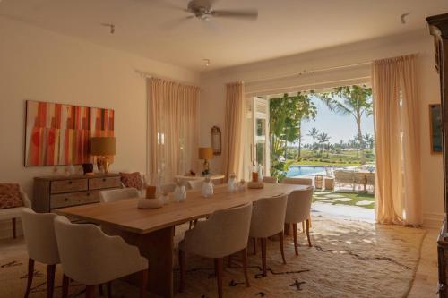 een eetkamer met een houten tafel en stoelen bij Unique lake-front 10-bedroom mansion in most luxurious resort of the caribbean in Punta Cana