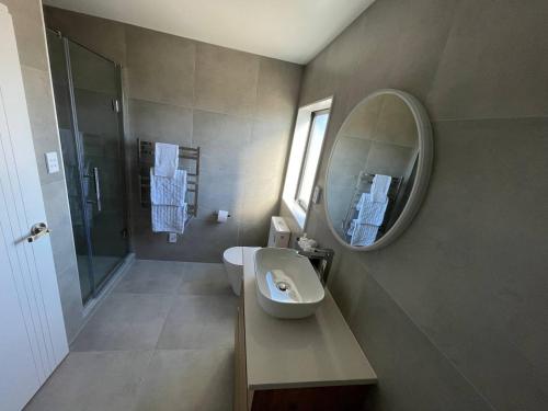 a bathroom with a sink and a mirror at 4 bedroom home fully furnished in Papakura, Auckland in Auckland