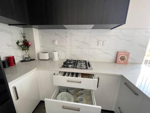 a kitchen with a stove and a white counter top at 4 bedroom home fully furnished in Papakura, Auckland in Auckland
