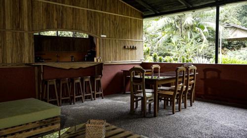 a room with a table and chairs and a kitchen at Playa Selva Lodge in Archidona