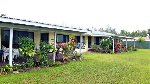 a house with a lawn in front of it at The Sundown Lodges Rarotonga in Arorangi