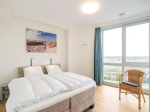 1 dormitorio blanco con 1 cama grande y 1 silla en Sea view apartment in Scherpenisse with terrace, en Scherpenisse