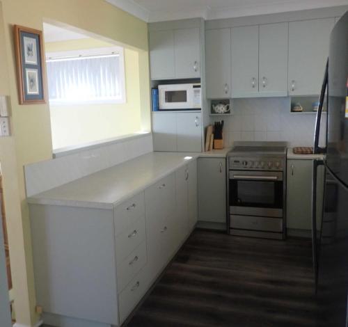 a kitchen with white cabinets and a stove top oven at Surf n View in North Haven