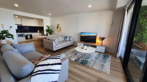 a living room with a couch and a table at Luxury Oceanview Apartment on Lvl 24 in Gold Coast