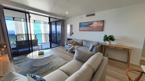 a living room with a couch and a table at OceanView Oasis 2BR Apt - 5Mins to Beach - Family Resort in Gold Coast