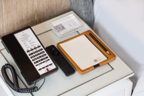 a telephone and a tablet sitting on a desk at Paco Hotel Canton Tower Pazhou-Free shuttle bus for canton fair in Guangzhou