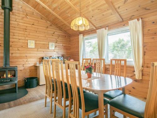 a dining room with a table and chairs and a fireplace at 9 person holiday home in Hurup Thy-By Traum in Sindrup