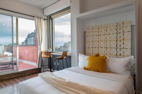 a bedroom with a bed and a large window at The Modernist Hotel in Long Island City