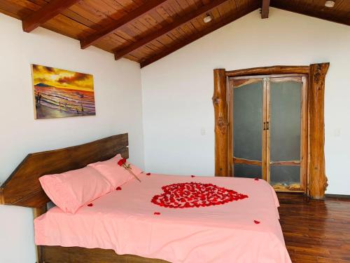1 dormitorio con cama con sábanas rosas y ventana en AYAR - Portentos & Cabañas NIDO DE AYAR, en Virú