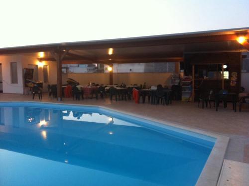 a swimming pool in front of a restaurant at B&B Terra Serena in Santa Cesarea Terme