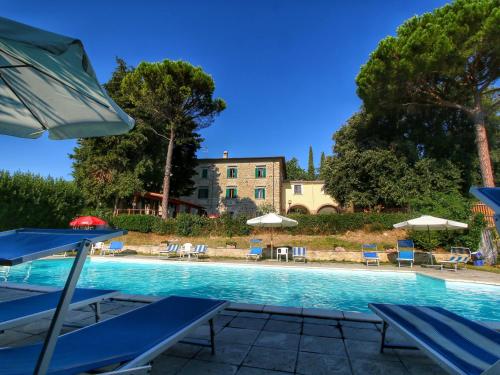 ein Pool mit Stühlen und Sonnenschirmen sowie ein Gebäude in der Unterkunft Belvilla by OYO I Molinari in Gualdo Cattaneo