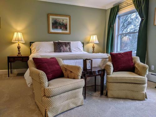 a bedroom with a bed and two chairs at Stanton House Inn in Greenwich