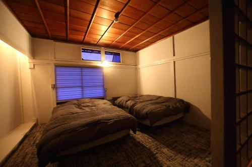 two beds in a small room with a window at HEM'S HOTEL 1日1組限定 new in Miyajima