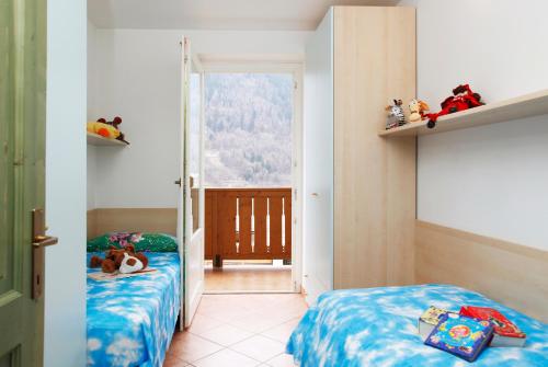 2 camas individuales en una habitación con ventana en Residenza Andreotti, en Ossana