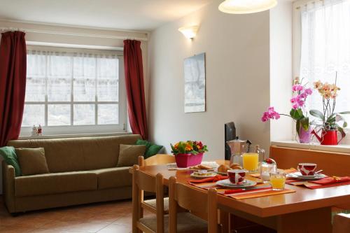 - un salon avec une table et un canapé dans l'établissement Residenza Andreotti, à Ossana