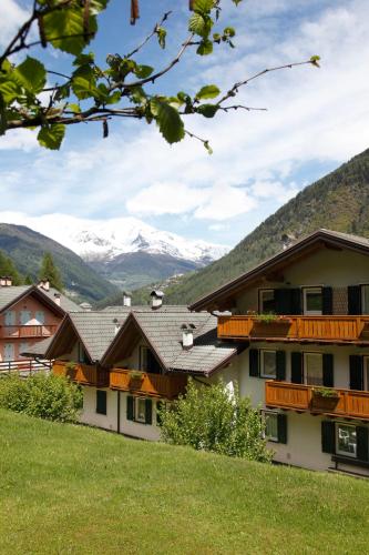 a group of buildings with snow covered mountains in the background at Residenza Andreotti in Ossana