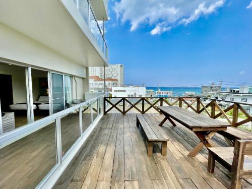 a wooden deck with a bench on top of a building at Coral Palace Onna by Sunset Avenue in Onna