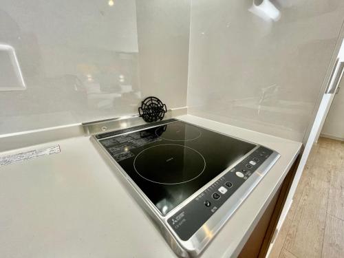 a stove top oven sitting in a white kitchen at Coral Palace Onna by Sunset Avenue in Onna