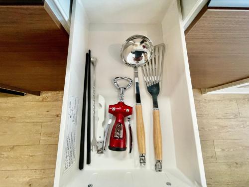 a shelf with utensils in a drawer at Coral Palace Onna by Sunset Avenue in Onna