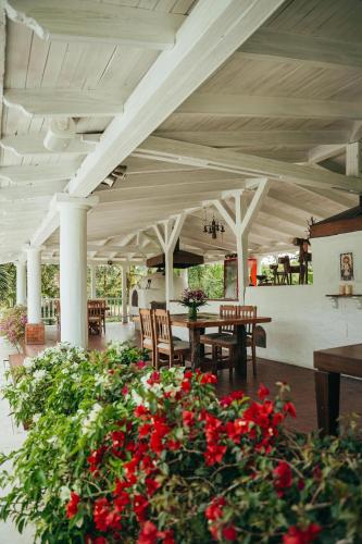 a patio with a table and chairs and red flowers at Hotel Boutique El Triángulo in Armenia