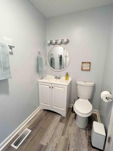 a bathroom with a white toilet and a mirror at Charming house in Sevierville Family friendly Quiet location Close to Wilderness in Sevierville