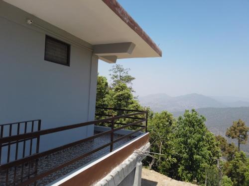 a balcony of a house with a view at Sharda Stay's Binsar Himalayas in Almora
