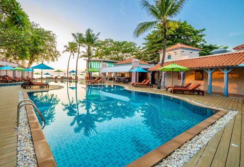 - une piscine dans un complexe avec des chaises et des parasols dans l'établissement Baan Samui Resort - SHA Extra Plus, à Chaweng