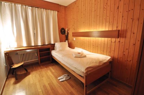 a bedroom with a bed in a wooden wall at La Villa Emeline - Apartment Emilie in Zermatt