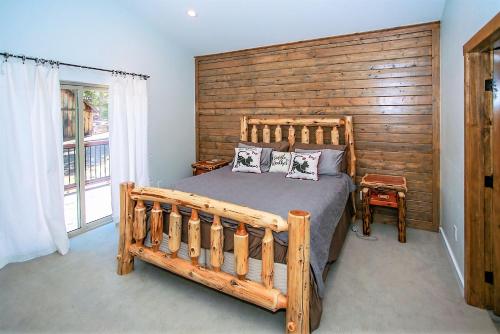 een slaapkamer met een groot bed en een houten muur bij Alpine Chalet-1840 by Big Bear Vacations in Big Bear Lake