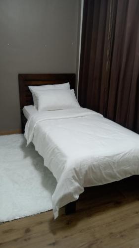 two beds with white sheets and pillows in a room at A2J Luxury BGC 2BR Loft Near Malls, Burgos Circle in Manila