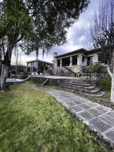 a house with a stone pathway in front of it at Hotel Hacienda San Miguel Regla in Huasca de Ocampo