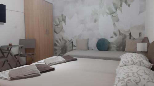 a bedroom with a white bed and a wall at Vicky Apartments in Kotor