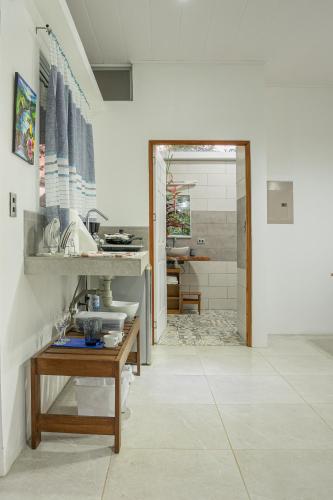 a kitchen with a sink and a table in a room at Agutipaca Bungalows in Bagaces